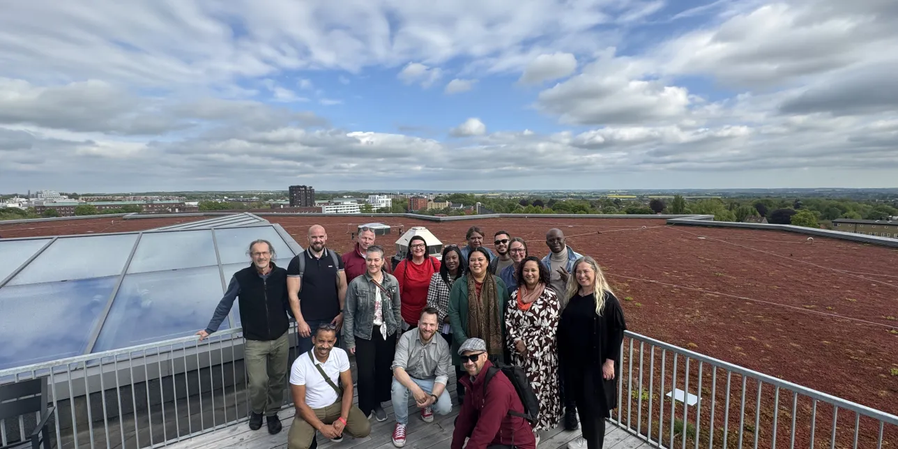 Group of people posing on roof. Photo.