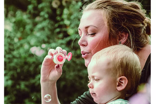 Strategic Plan cover page, woman with a small child blowing soap bubbles, photo. 
