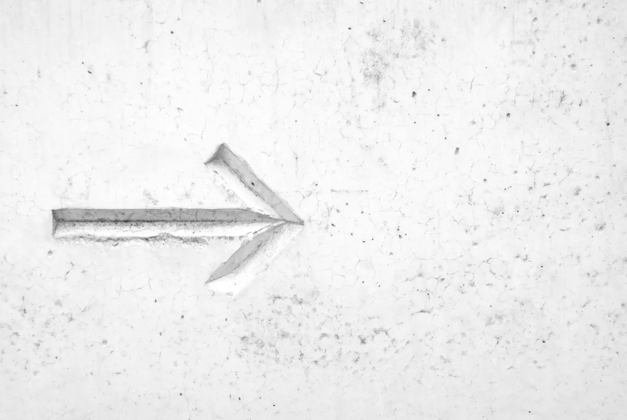 The image shows a gray arrow on a gray background. The arrow points to the right.