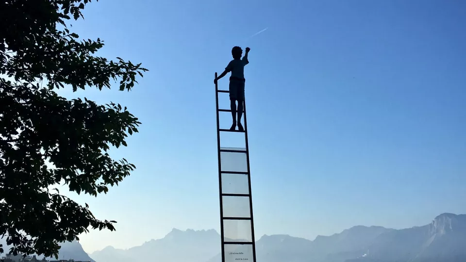 Person som klättrar på en stege utan stöd. Foto. 