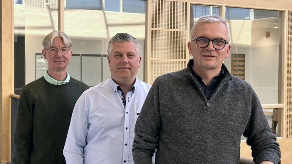 De tre forskarna står på rad på balkong i atrium i i Diagnostiskt centrum på sjukhusområdet i Malmö.