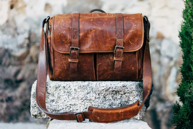 En brun portfölj som står utomhus på en sten