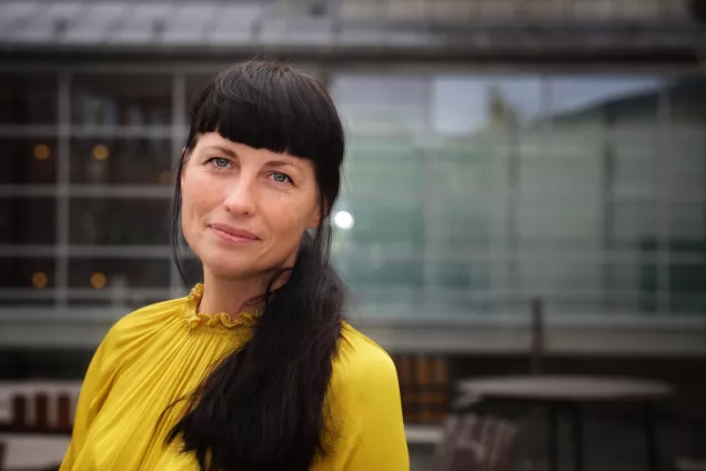 Porträtt kvinna i gul topp. Foto.