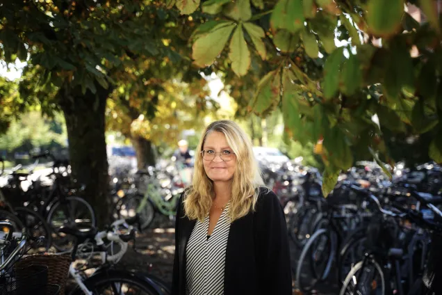 kvinna bland parkerade cyklar. foto.