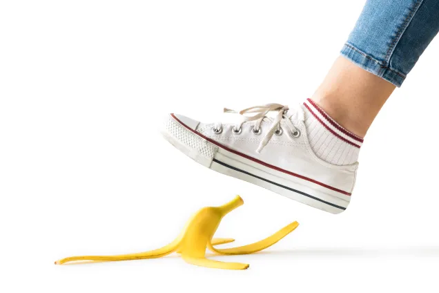 Fot halkar på bananskal. Foto.