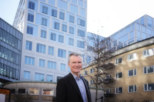 man med hus bakom. foto.