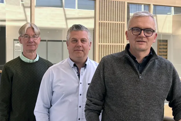 De tre forskarna står på rad på balkong i atrium i i Diagnostiskt centrum på sjukhusområdet i Malmö.
