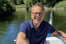 Mattias Brattström vid rodret på en båt en fin sommardag. Foto.
