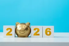 Guldfärgad spargris som bildar nollan i årtalet 2026. Foto.